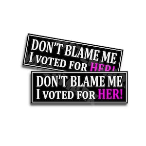 May include: Two black and white stickers with the text "Don't blame me I voted for HER!" in white letters with the word "HER!" in pink letters.