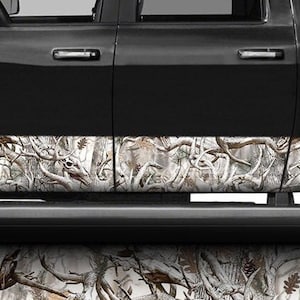 May include: A black pickup truck with a white and brown camouflage pattern on the side steps. The truck has a "RAM 2500" emblem on the side.