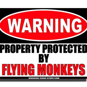 May include: A black and red warning sign with the text "WARNING PROPERTY PROTECTED BY FLYING MONKEYS" and the website "WARNING SIGNS STORE.COM" at the bottom.
