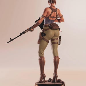 May include: A detailed figurine of a woman in combat attire, holding a rifle. She wears a blue corset, brown leather straps, and olive green pants. Brown boots and a holster complete the look. The figure stands on a black base.