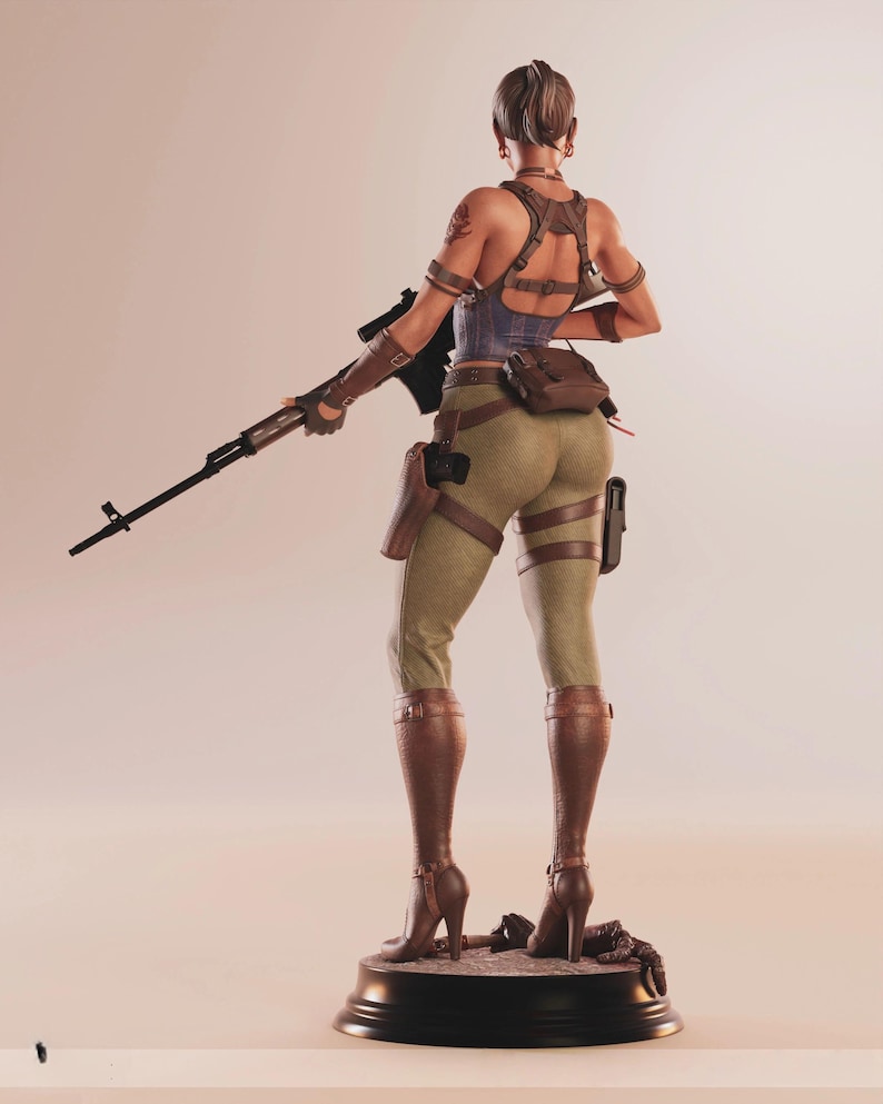 May include: A detailed figurine of a woman in combat attire, holding a rifle. She wears a blue corset, brown leather straps, and olive green pants. Brown boots and a holster complete the look. The figure stands on a black base.