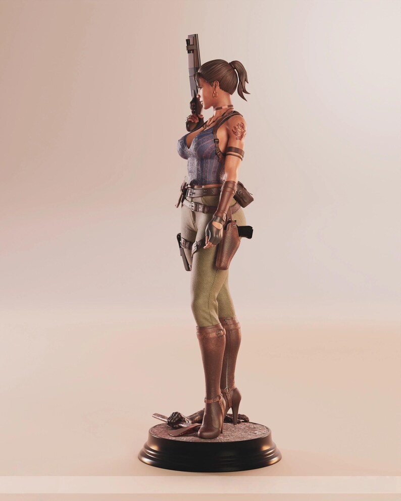 May include: A detailed figurine of a woman in a blue top, green pants, and brown boots, holding a gun. The figure has a ponytail and is standing on a black base. Accessories include a holster and a tattoo on the arm.