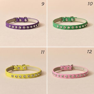 May include: Four pet collars labeled 9, 10, 11, and 12. Each collar features a row of clear, round rhinestones embedded in a smooth band. The collars are purple, green, yellow, and pink, each with a silver-toned metal buckle and rivets.