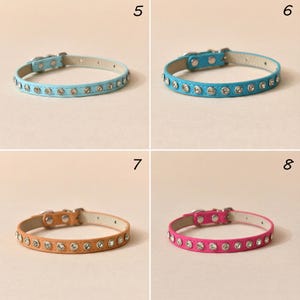 May include: Four pet collars in light blue, bright blue, tan, and hot pink. Each collar features a row of embedded clear rhinestones, a silver-toned metal buckle, and a matching metal loop. The collars are numbered 5, 6, 7, and 8 respectively.