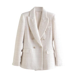 May include: A cream-colored double-breasted blazer with gold-colored buttons. The blazer has a textured fabric and a classic notched lapel. The jacket features two front pockets and a tailored fit, suitable for formal or business attire.