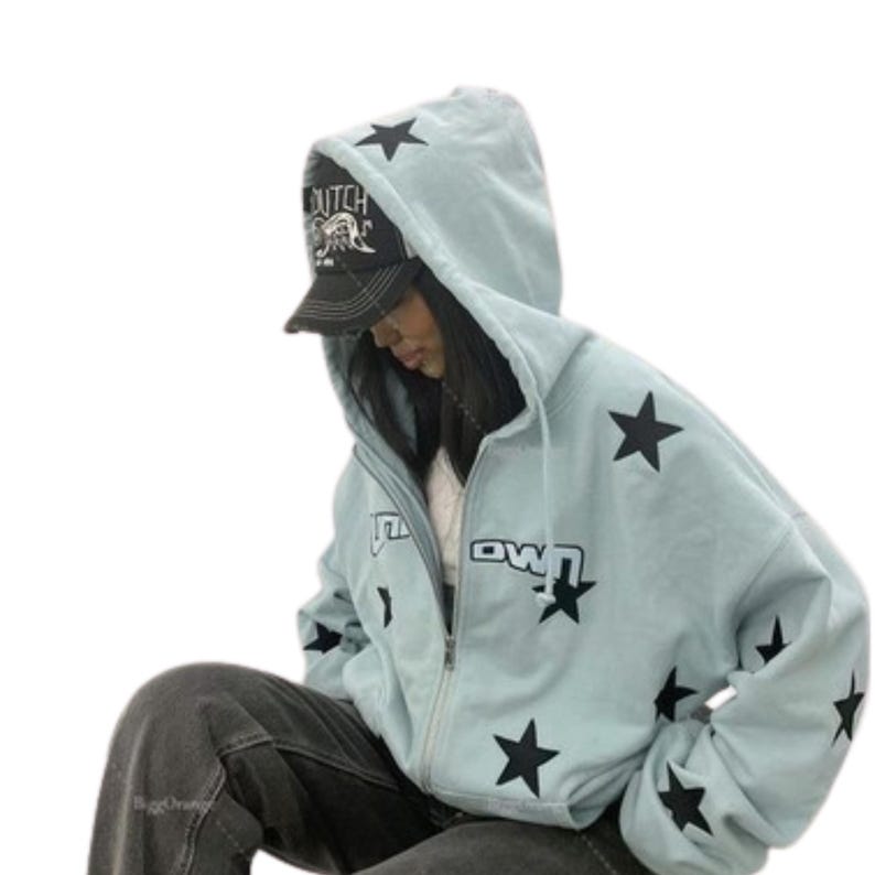 Puede incluir: Sudadera con capucha azul claro con estrellas negras y la palabra "Downtown" impresa. La sudadera con capucha se usa con una gorra de b&eacute;isbol negra. La sudadera tiene capucha.