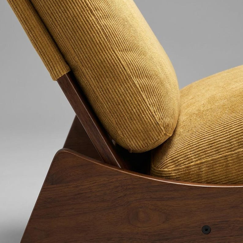 Pu&ograve; includere: Primo piano di una sedia moderna di met&agrave; secolo. La sedia presenta una struttura in legno scuro e cuscini in velluto a coste giallo senape. Il design include supporti angolati e uno schienale curvo.