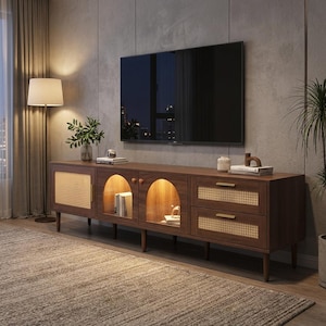 May include: A mid-century modern TV stand in a living room. The brown wooden cabinet has woven cane details, arched glass doors, and drawers with brass handles. A large black television is mounted above the unit. The cabinet is approximately 180cm long.