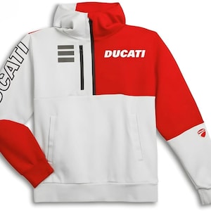 May include: A white and red quarter-zip pullover sweatshirt featuring the word DUCATI printed in white on the chest and in black on the right sleeve. The garment includes a black zipper, a small Ducati logo on the left sleeve, and three grey stripes.