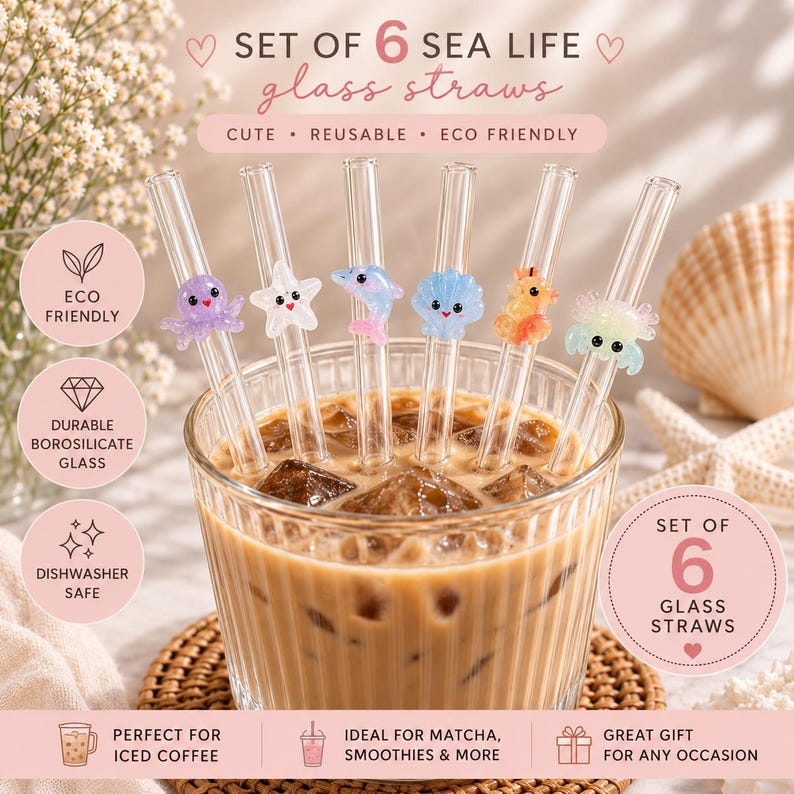 May include: A set of six clear borosilicate glass straws featuring colorful sea life charms including an octopus, starfish, dolphin, seashell, seahorse, and crab. The straws are displayed in a glass filled with iced coffee and ice cubes.
