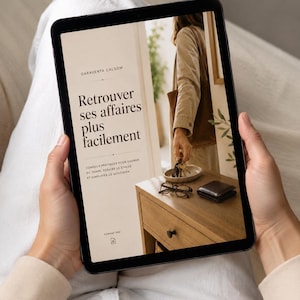 May include: A tablet displaying a digital document titled Garaventa Calsom Retrouver ses affaires plus facilement. The screen shows a photograph of a person placing keys on a wooden table next to glasses and a wallet, with text below the title.