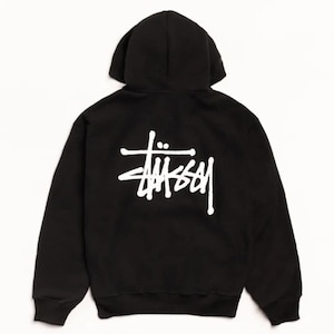 Pode incluir: Uma camisola com capuz preta com o logótipo Stüssy impresso a branco nas costas. A peça inclui um capuz, mangas compridas com punhos canelados e uma bainha canelada. O tecido é preto sólido e o gráfico branco está posicionado ao centro.