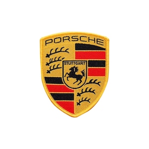 Può includere: Toppa ricamata con lo stemma Porsche. Lo stemma a forma di scudo ha uno sfondo giallo, strisce nere e rosse e un cavallo nero al centro. La parola "PORSCHE" è arcuata nella parte superiore e "STUTTGART" è sotto il cavallo.