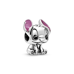 A small, silver-colored charm in the shape of a cartoon character with large eyes and pink ears.