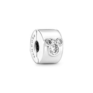 A silver-colored pendant charm with a crystal or gemstone in the center, resembling a Minnie Mouse design.