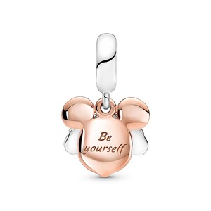 A charm in the shape of a Mickey Mouse's head with the text "Be yourself" engraved on it.