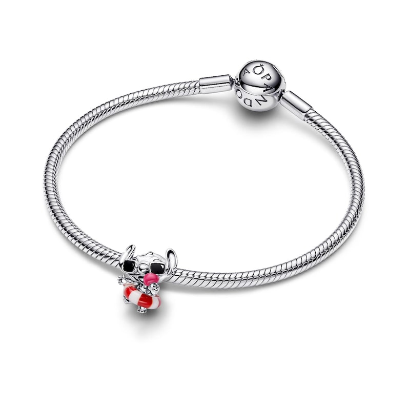 A silver-colored charm bracelet with a small charm depicting a cartoon character and a round bead on the end.
