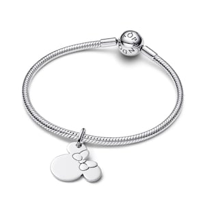 A silver-toned bracelet with a charm featuring a Minnie Mouse design.