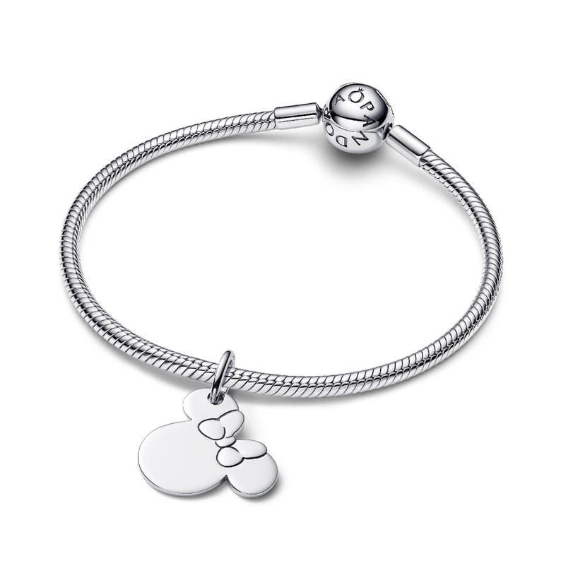 A silver-toned bracelet with a charm featuring a Minnie Mouse design.