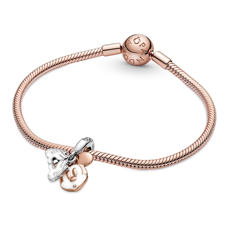 A rose gold-colored bracelet with a charm and a bead attached to it.