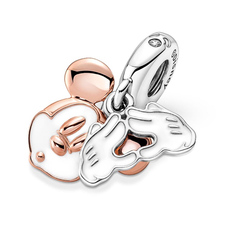 a collection of charms, including a silver charm with a heart-shaped design, a silver charm with a bird-shaped design, and a silver charm with a hand-shaped design.