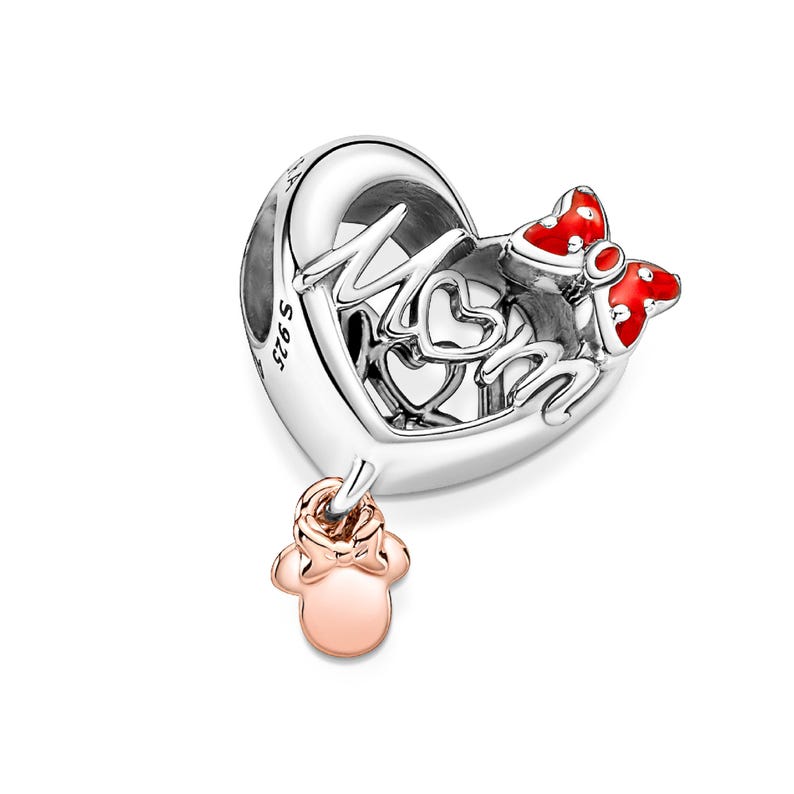 A silver heart-shaped charm with the word "MOM" written on it, along with two red bows. The charm also has a small pink charm attached to it.