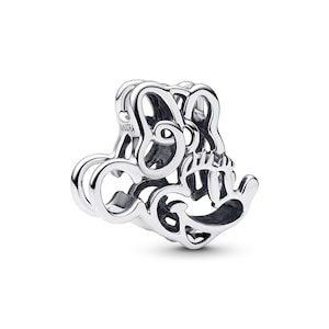 A silver-colored charm bracelet with an intricate, abstract design.