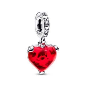 A red heart-shaped charm with a silver pendant attached to it.