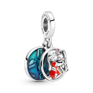 A silver-colored charm pendant with a blue and red design, featuring a small animal figure.