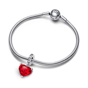 A silver-toned bracelet with a red heart-shaped charm and a silver-toned bead attached to it.