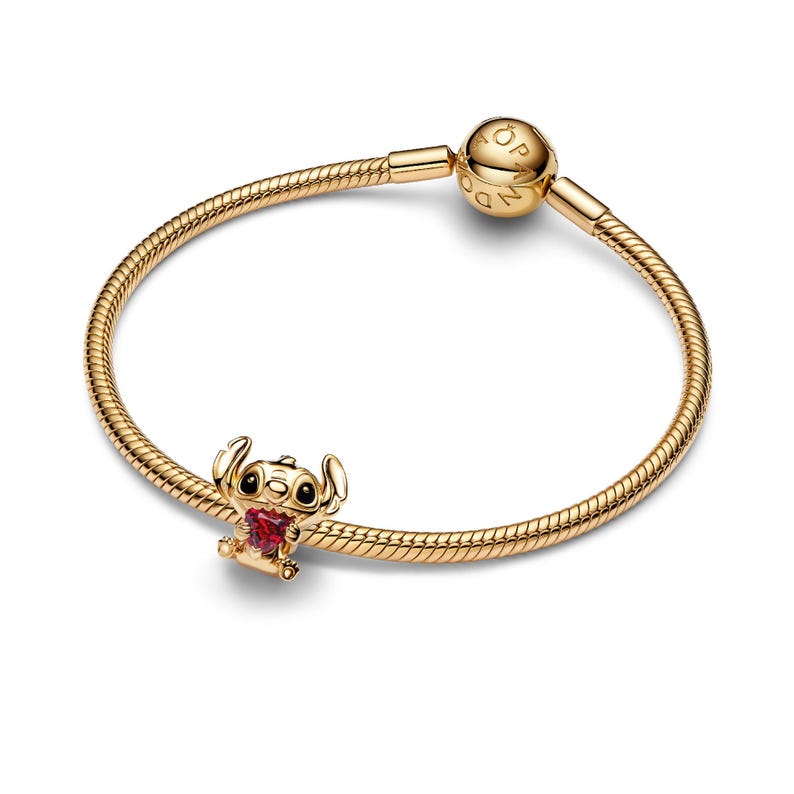A gold-colored bracelet with a charm featuring a cartoon character.