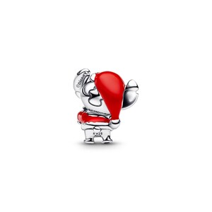 A silver charm in the shape of a small red character wearing a red hat.