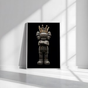 Pu&ograve; includere: Opera d'arte incorniciata raffigurante una figura stilizzata con le braccia incrociate, con una corona d'oro. La figura ha un aspetto strutturato, grigio scuro su sfondo nero. L'opera &egrave; esposta in una cornice bianca.