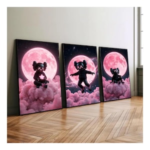 May include: Three framed art prints. Each print features a black figure with XX eyes set against a pink moon and cloud background. The figure is in different poses in each print, with a star, jumping, and sitting.