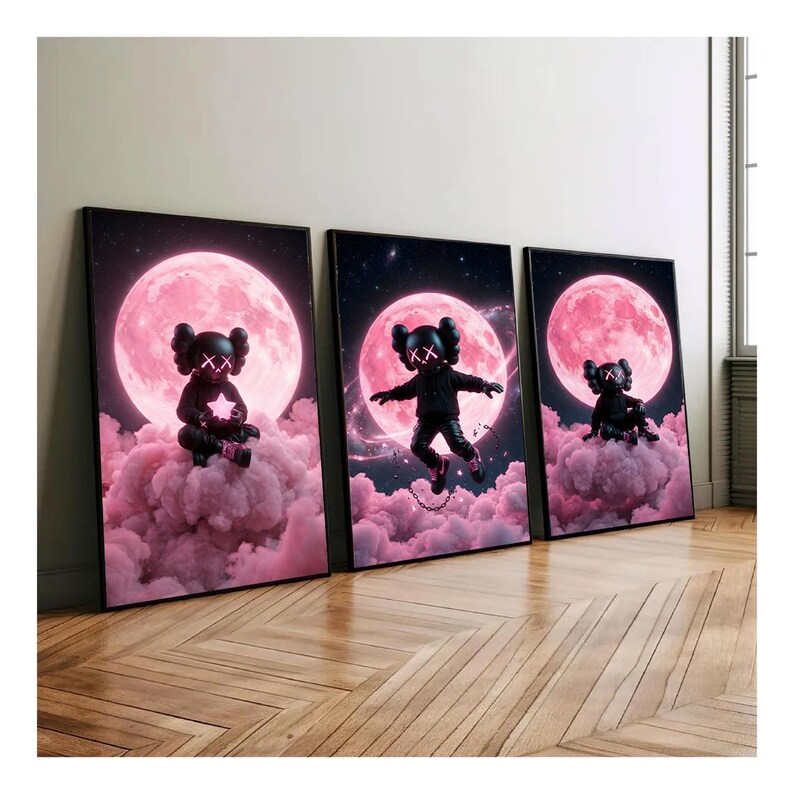 May include: Three framed art prints. Each print features a black figure with XX eyes set against a pink moon and cloud background. The figure is in different poses in each print, with a star, jumping, and sitting.