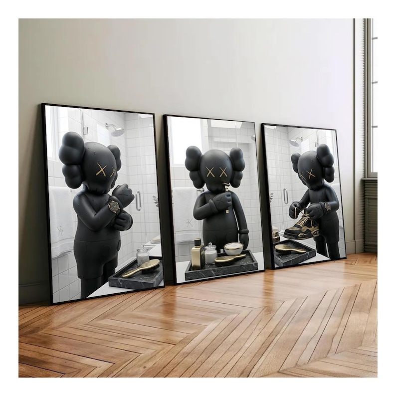 May include: Three framed wall art prints featuring a black cartoon character with X-shaped eyes in a bathroom setting. The character is shown in different poses: adjusting a watch, holding a toothbrush, and tying a sneaker. Each print has a black frame.