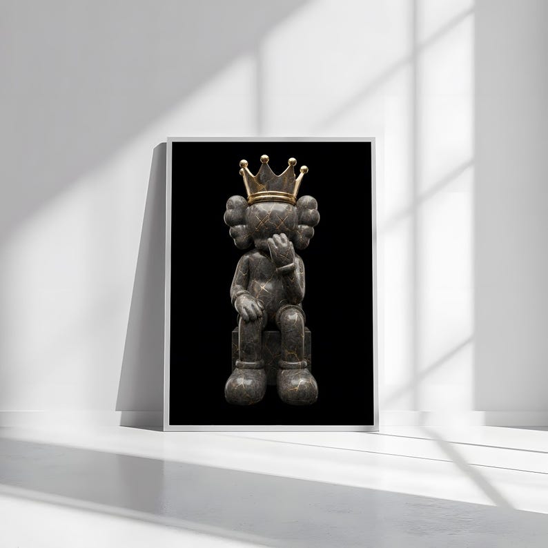 Pu&ograve; includere: Opera d'arte incorniciata con una figura seduta con una corona d'oro. La figura &egrave; grigio scuro con venature dorate, seduta su un blocco grigio scuro su sfondo nero. L'opera &egrave; esposta in una cornice bianca.