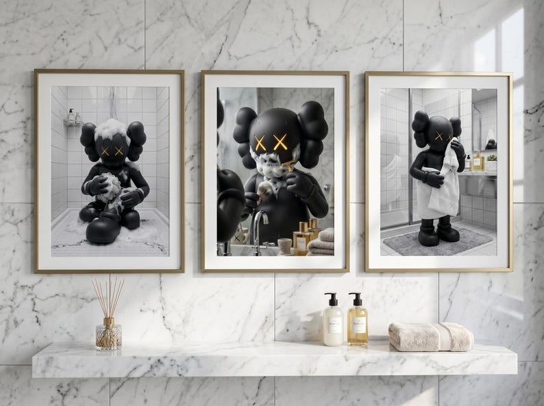 May include: A set of three framed wall art prints featuring a black cartoon character with X-shaped eyes in a bathroom setting. The first shows the character bathing, the second shaving, and the third drying off with a white towel in a marble room.