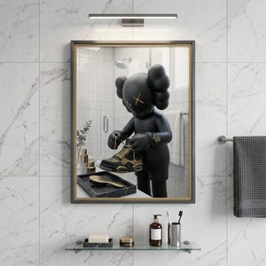 May include: A rectangular wall mirror with a dark frame displaying a reflection of a black cartoon-style figure with X-shaped eyes. The figure is holding a black and gold sneaker. The mirror is mounted on a white marble-tiled wall above a glass shelf.