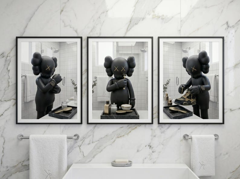 May include: A set of three framed wall art prints featuring a black KAWS character in a bathroom setting. The character is shown adjusting a watch, brushing teeth, and holding a sneaker. Each print is displayed in a thin black frame.