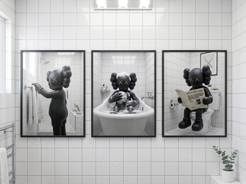 May include: A set of three framed wall art prints featuring a black KAWS character in a white tiled bathroom. The first shows the character reaching for a towel, the second bathing in a tub, and the third sitting on a toilet reading a newspaper.