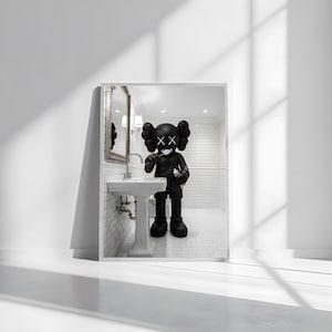 May include: A framed print featuring a black and white illustration of a cartoon figure brushing its teeth in a bathroom setting. The figure has large, round ears and X-shaped eyes. The bathroom includes a sink, mirror, and tiled walls.