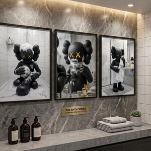 May include: Three framed wall art prints titled THE BATH SERIES KAWS INSPIRED COLLECTION. Each print features a black cartoon character with X-shaped eyes in a bathroom setting, including bathing, shaving, and drying with a white towel.