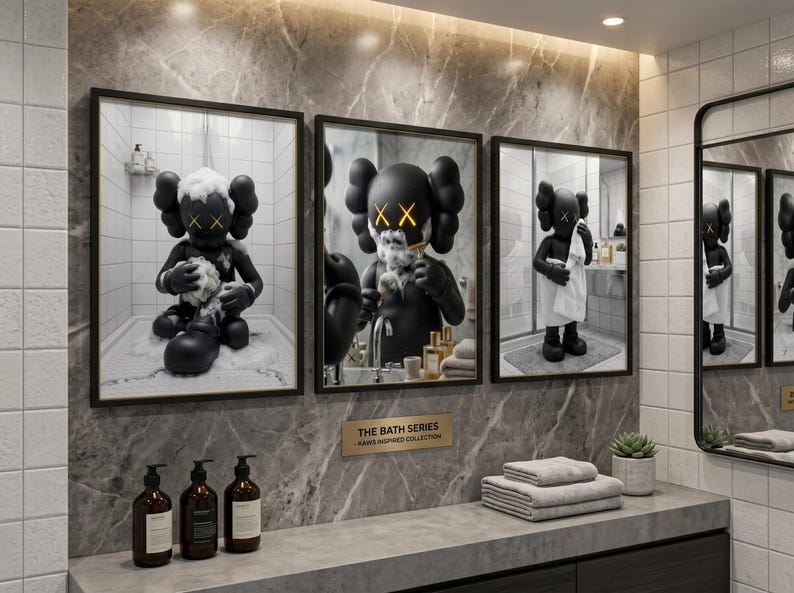 May include: Three framed wall art prints titled THE BATH SERIES KAWS INSPIRED COLLECTION. Each print features a black cartoon character with X-shaped eyes in a bathroom setting, including bathing, shaving, and drying with a white towel.