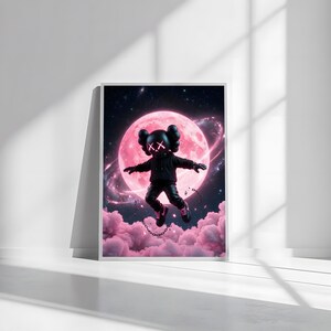 May include: Framed art print showing a black figure with 'XX' eyes, against a pink moon and clouds. The figure wears a black hoodie, trousers, and shoes, with a chain. The background is a starry night sky, creating a surreal scene.