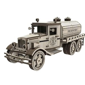 May include: A wooden model of a vintage fire truck. The truck features a detailed design with visible wheels, a cab, and a water tank labeled "FIRE DEPARTMENT". The model is made of light-colored wood with darker wood accents.
