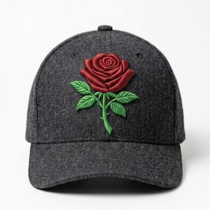 Puede incluir: Gorra de béisbol gris oscuro con una rosa roja bordada y hojas verdes. La gorra tiene una visera curva y una corona redondeada. Un accesorio de moda.