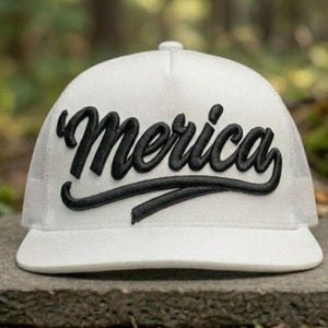 Könnte beinhalten: Weiße Baseballkappe mit Mesh-Rückseite und gebogenem Schirm. Auf der Kappe ist das Wort "Merica" in schwarzer Schrift gestickt. Die Kappe liegt auf einer Steinoberfläche.