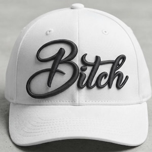 Puede incluir: Una gorra de béisbol blanca con la palabra Bitch bordada en relieve en una fuente cursiva negra en los paneles frontales. La gorra tiene una corona estructurada, una visera curva y un botón en la parte superior, mostrando un diseño contrastado.