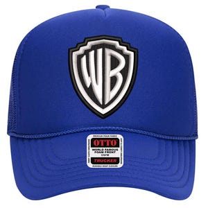 May include: A royal blue trucker hat with a white and black WB logo on the front. The hat has a foam front and a mesh back. The hat has a snap closure and a small tag that says "OTTO".